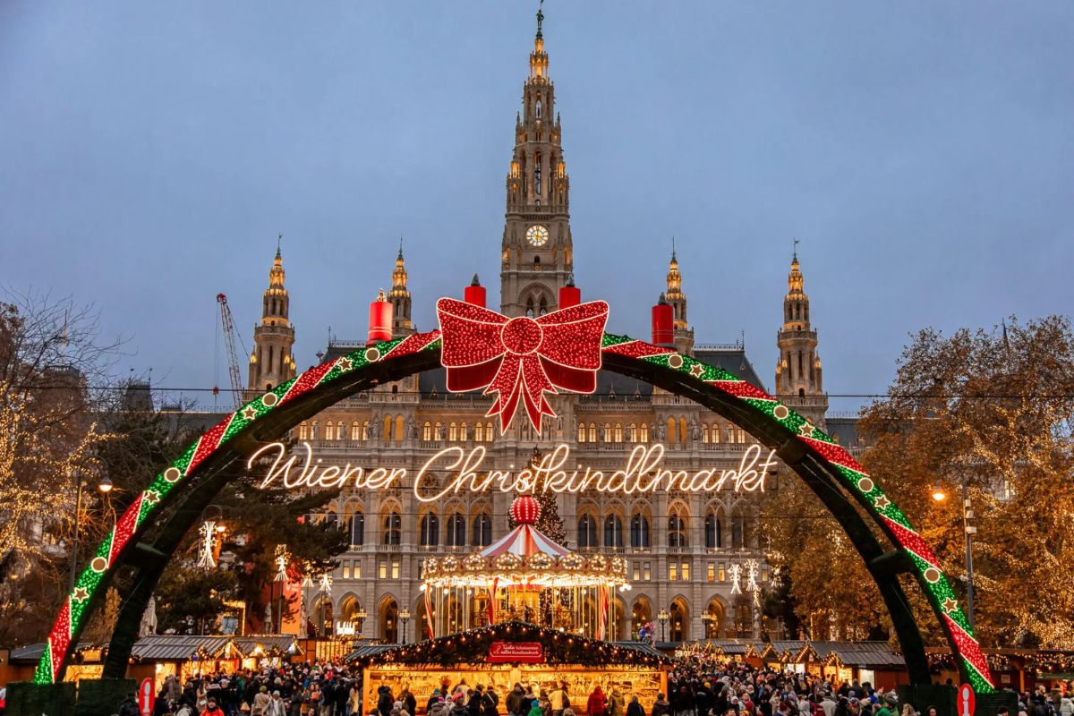 Mercatino di Natale Vienna Rathausplatz: ingresso illuminato Wiener Christkindlmarkt con Municipio neogotico sullo sfondo